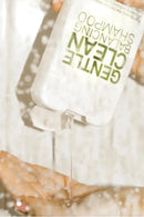 Hand pouring a clear liquid from a bottle labeled 'Gentle Clean' into another container - Hair Care Canada