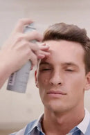 Person applying hair spray to a man's hair indoors - Hair Care Canada